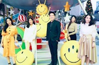 a group of people posing in front of a smiley face