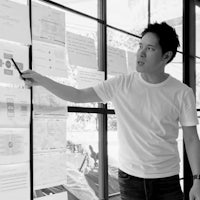 a man standing in front of a window with papers on the wall