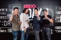 a group of men standing in front of a sign that says bdo