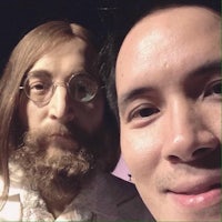 a man is taking a selfie with a mannequin of john lennon