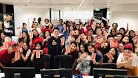 a group of people posing for a photo in an office