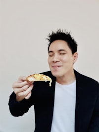 a man is eating a piece of pizza