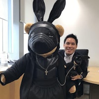 a man in a suit poses with a stuffed bunny