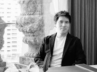 a man sitting at a desk in front of a window