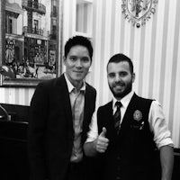 two men standing next to each other giving thumbs up