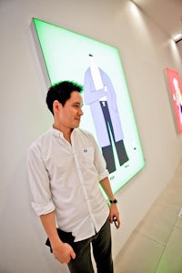 a man standing in front of a group of paintings