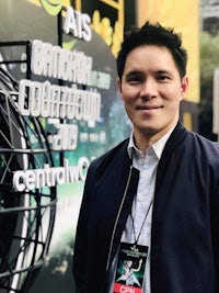 a man in a jacket standing in front of a globe