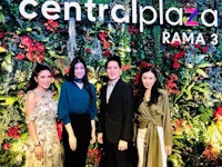 a group of people standing in front of a sign that says central plaza rama 3
