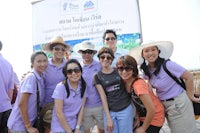 a group of people in purple shirts posing for a photo
