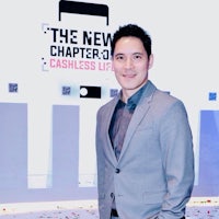 a man in a suit standing in front of confetti