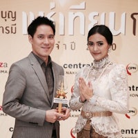 a man and woman posing for a photo with an award