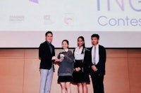 a group of people posing for a picture in front of a screen