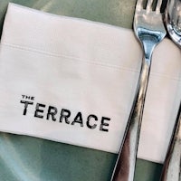 the terrace napkin on a plate with a fork and knife