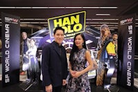 a man and woman standing in front of a star wars movie poster